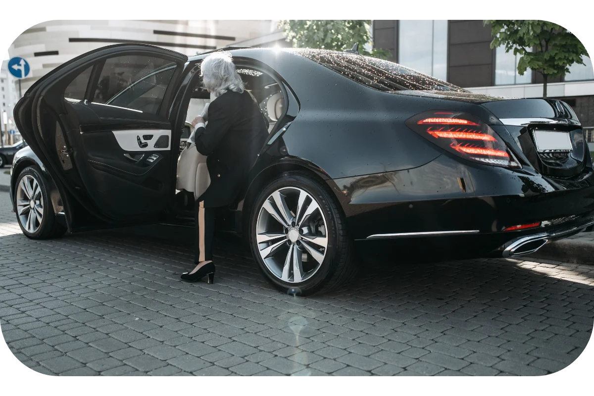MCO Luxury chauffeur opening rear door of black sedan for executive transportation Orlando